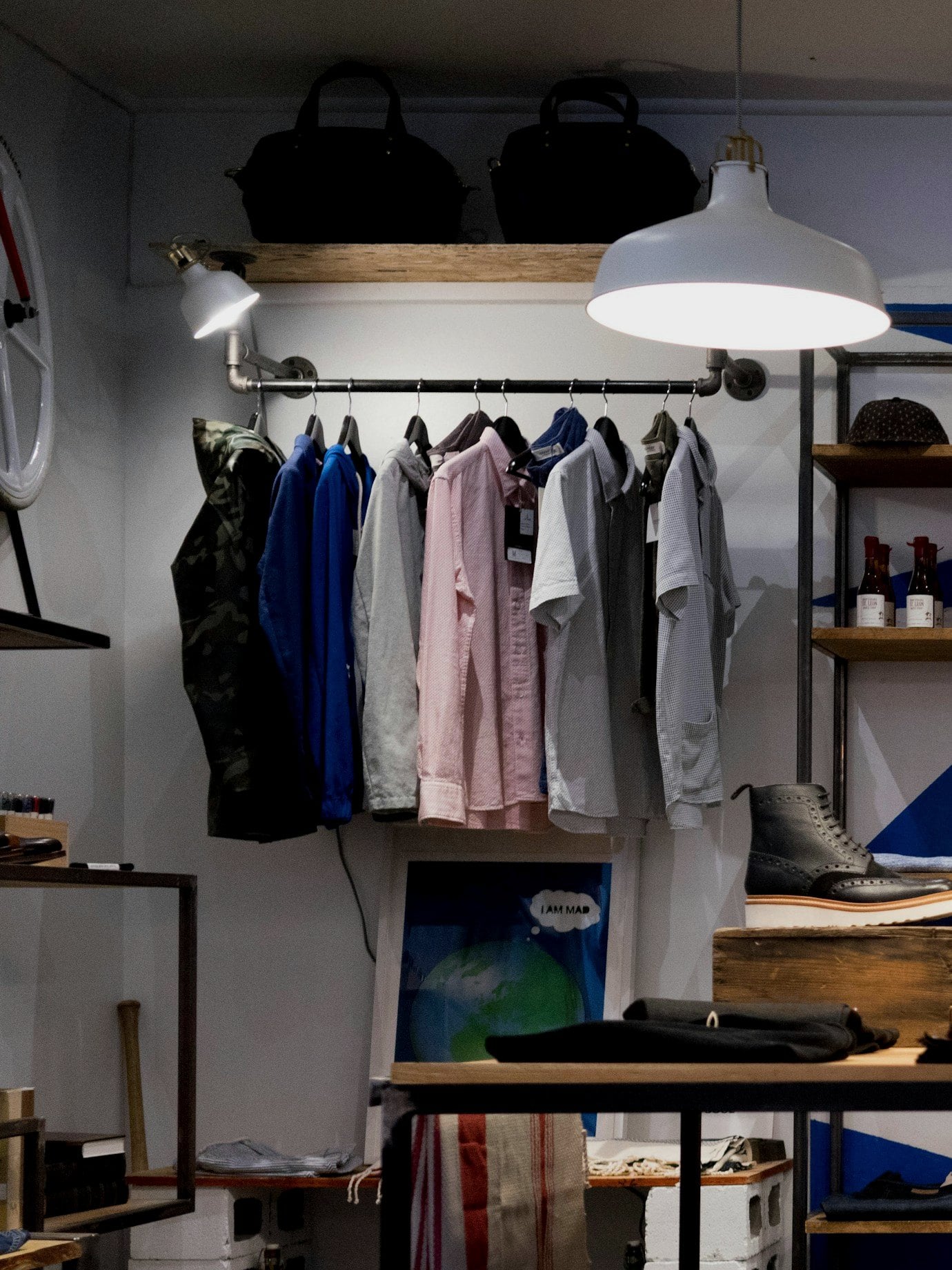 Boutique clothing rail under white pendant lamps.